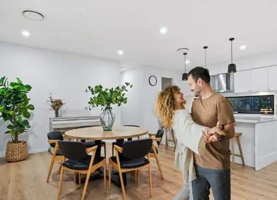 Happy couple dancing in their new home built by Omni Built Homes